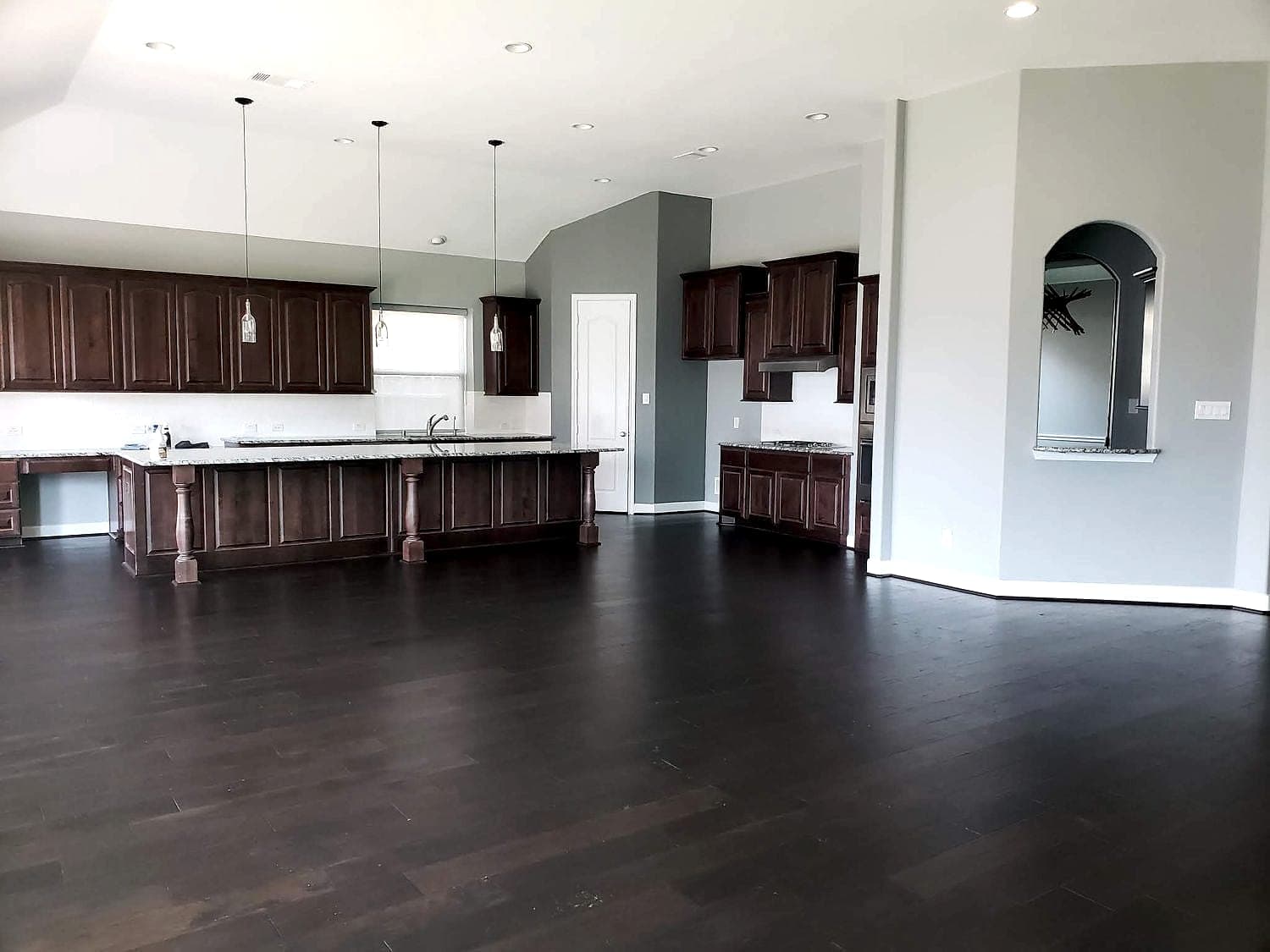 Dark hardwood floor through an open-plan kitchen and living room, installed by Floor Gallery